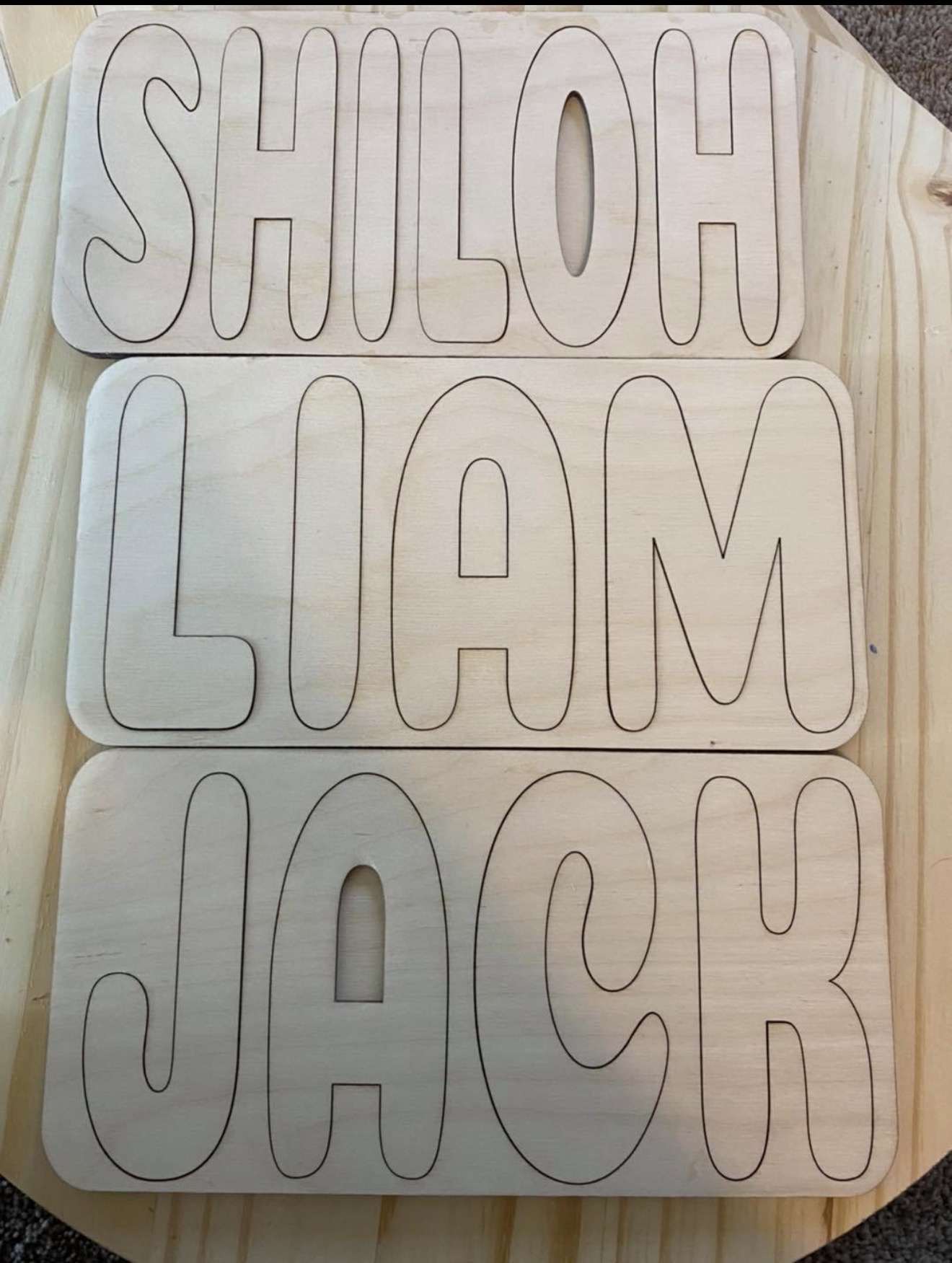 Laser-cut wooden name signs: Shiloh, Liam, and Jack.